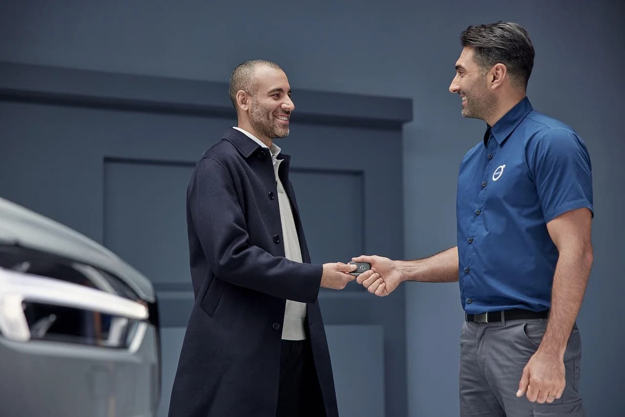 Couple receiving car keys at a dealership - Car Loan Interest Rates Australia